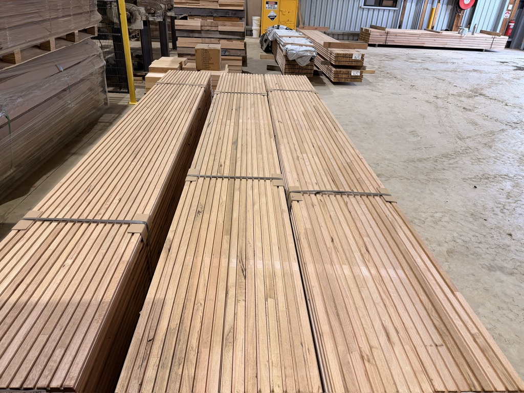 Stacks of machined CASE hardwood infill with pale pink, straw and darker natural grain variation